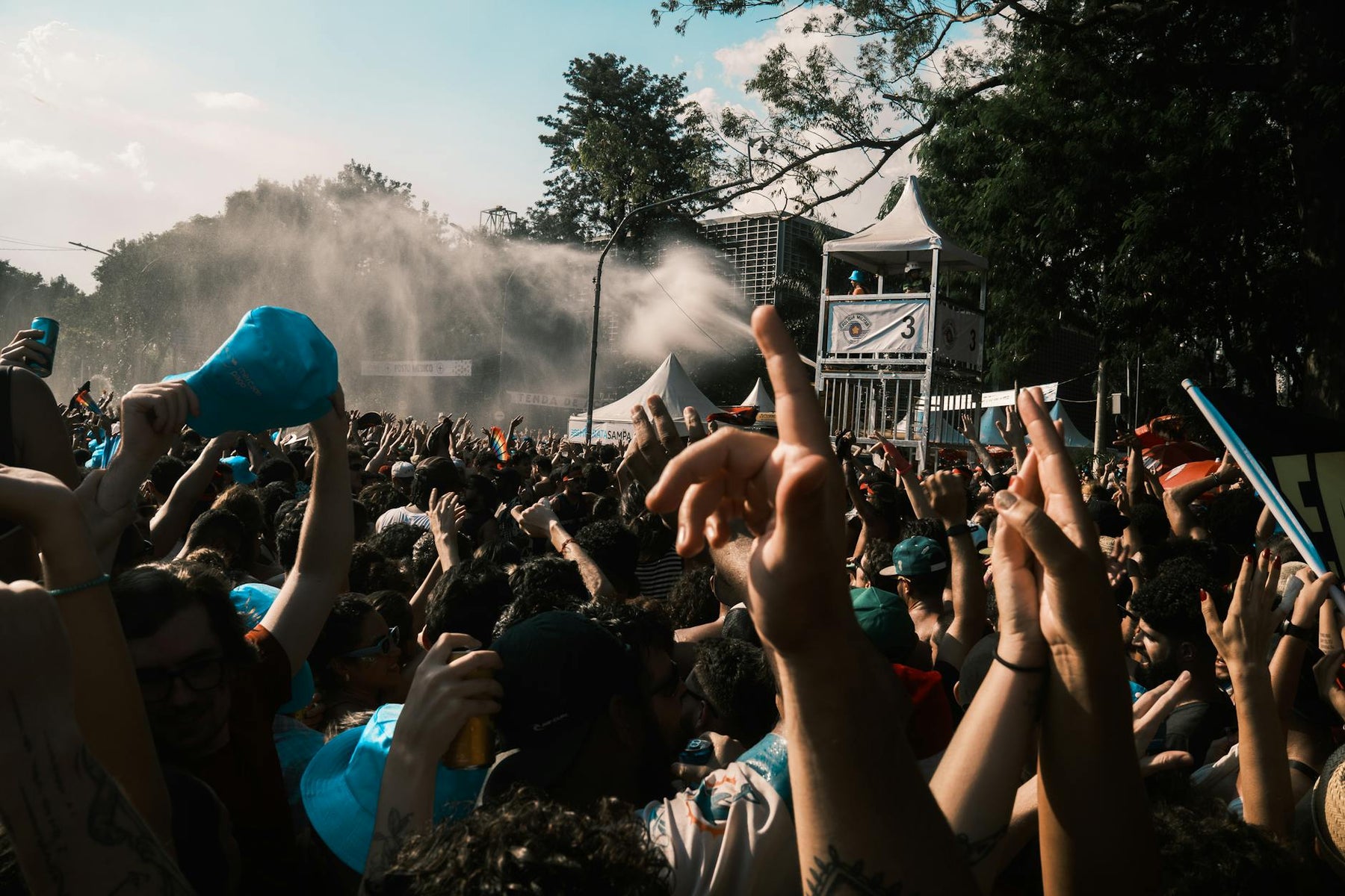 Vibrant crowd enjoying an outdoor music festival on a sunny day.