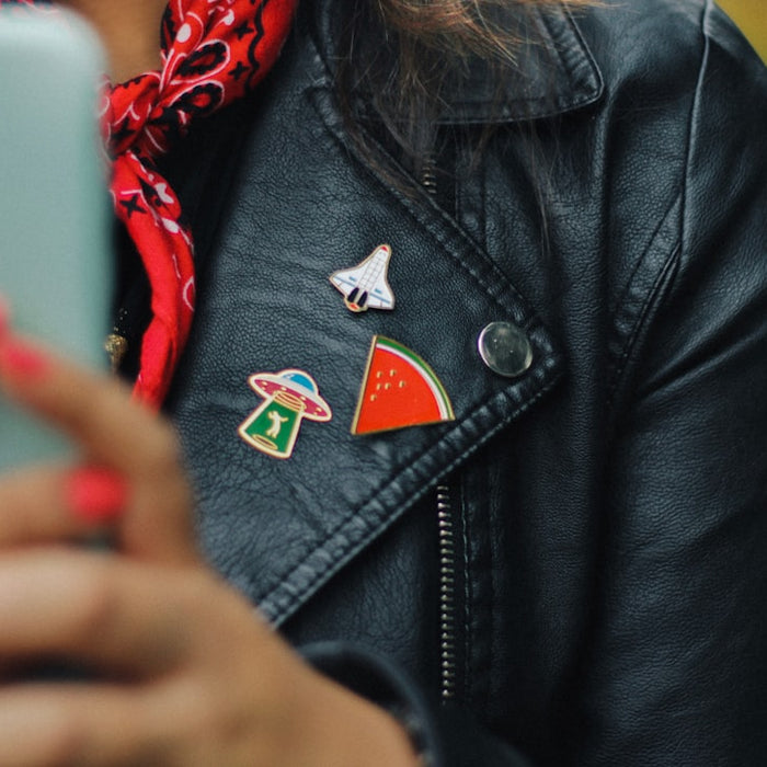 person wearing black leather jacket holding mobile phone