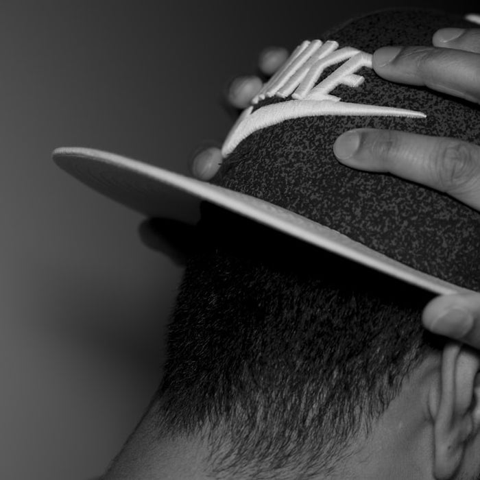 grayscale photography of man wearing cap