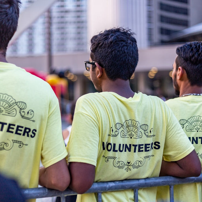 three men wearing yellow Volunteers shirts