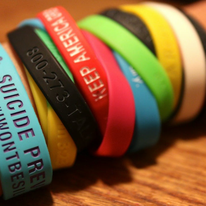 person wearing multiple silicone bands
