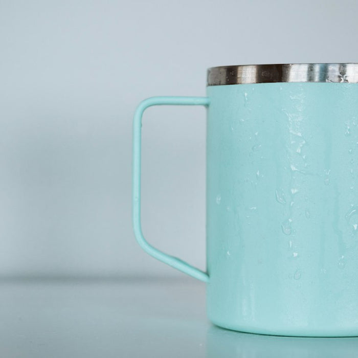 shallow focus photo of teal mug