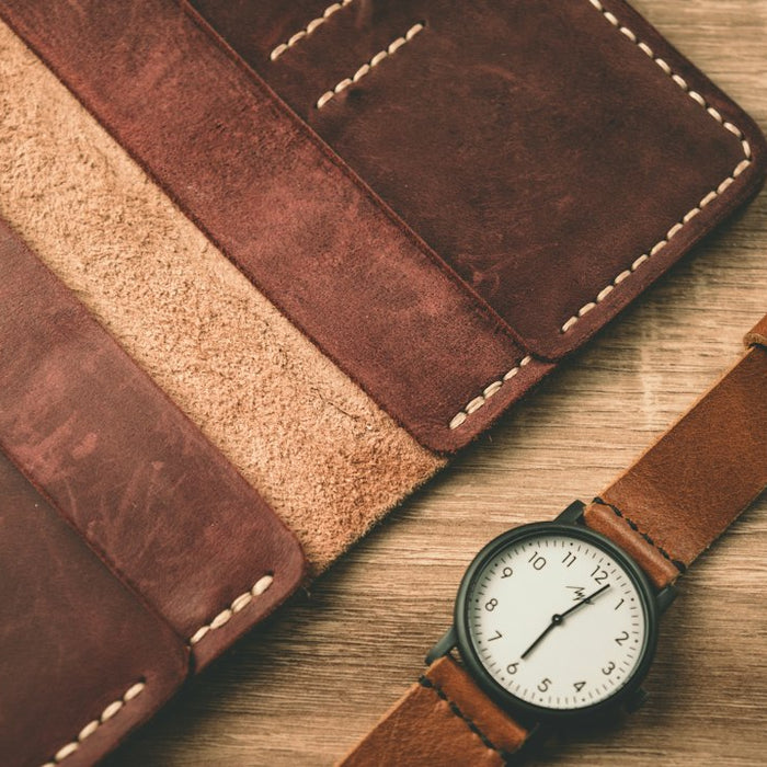 a watch sitting next to a wallet on a table