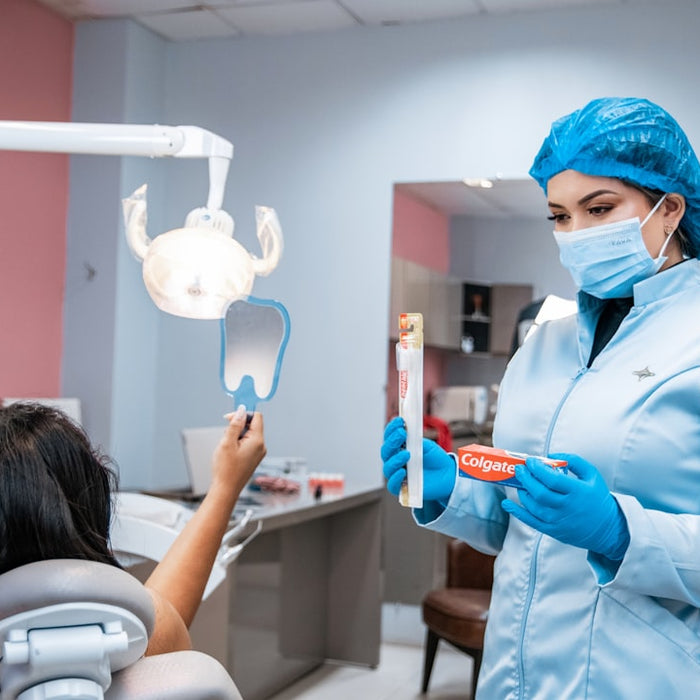 a woman in a dentist's office holding a toothbrush