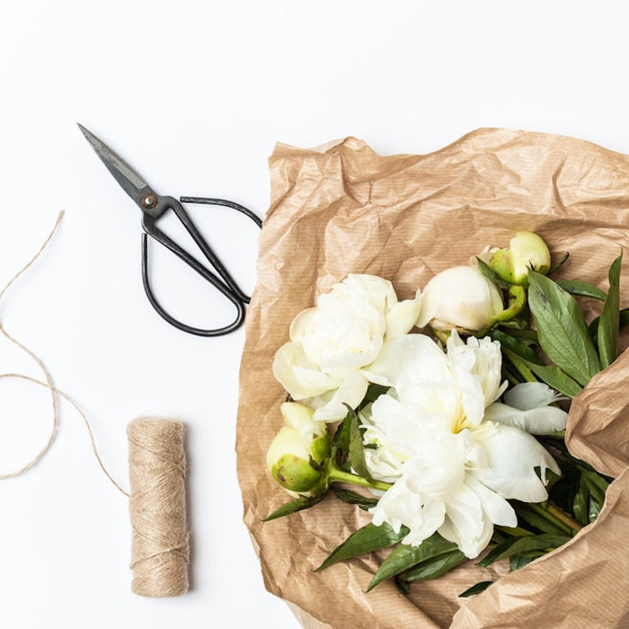 a bunch of flowers sitting in a bag next to a pair of scissors