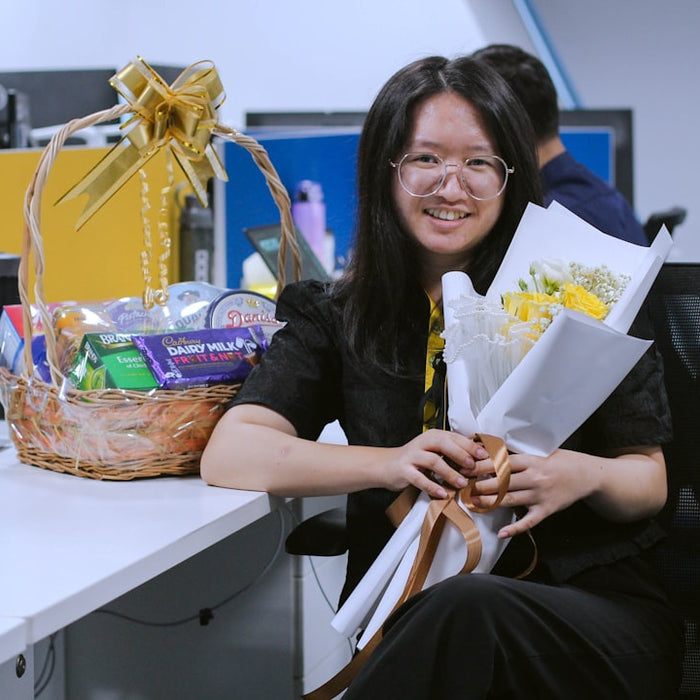 a woman sitting at a desk with a basket of flowers