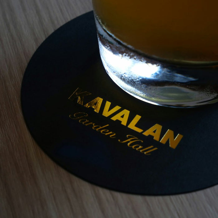 a glass of beer sitting on top of a wooden table