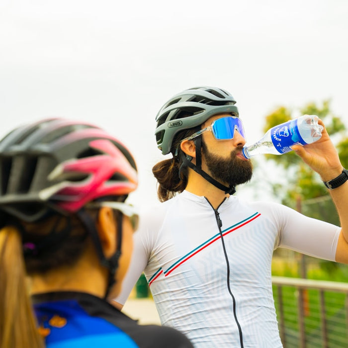 a man with a beard drinking water from a bottle