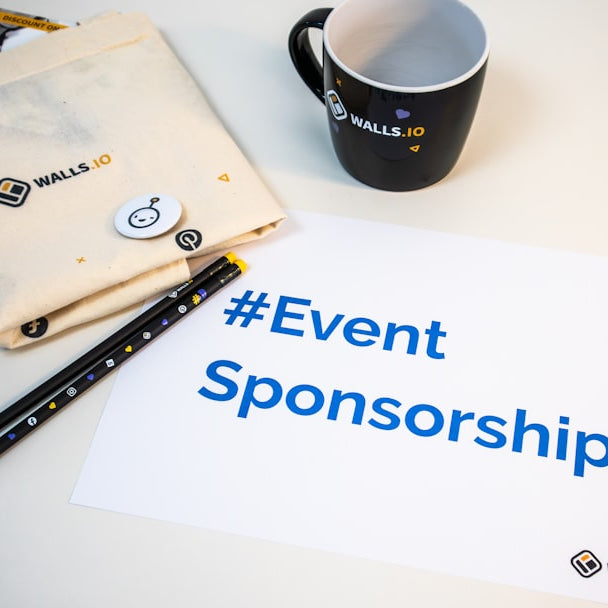 a cup of coffee next to a sign that says event sponsor