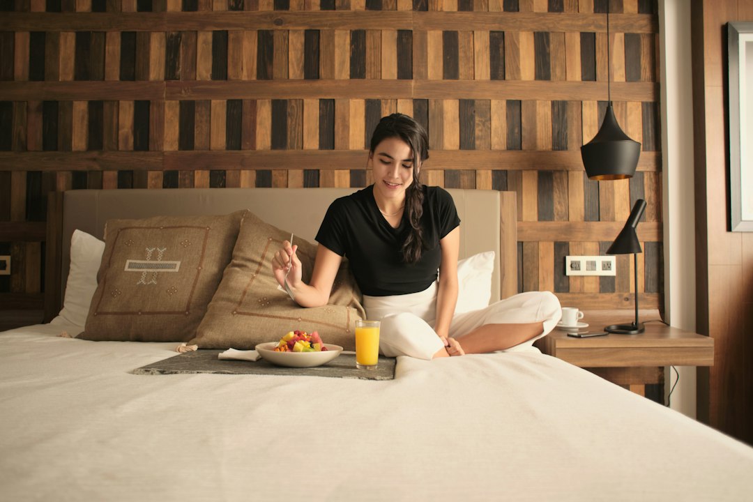 A woman sitting on a bed in a hotel room
