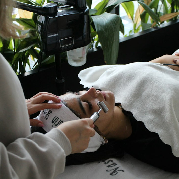 A woman laying on a bed while using a cell phone