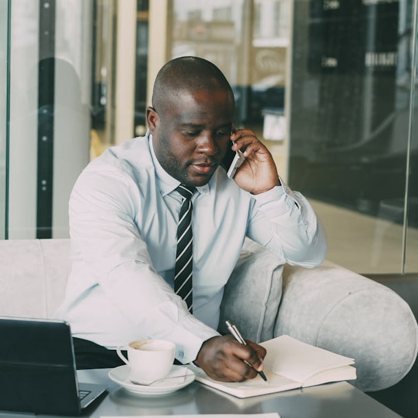 Man on phone taking notes at desk