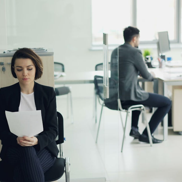Woman sitting in office holding papers