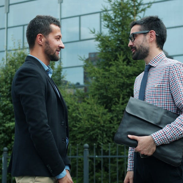 Two businessmen talking outside modern building
