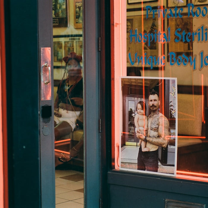 Tattoo parlor entrance with neon lights and displayed art.