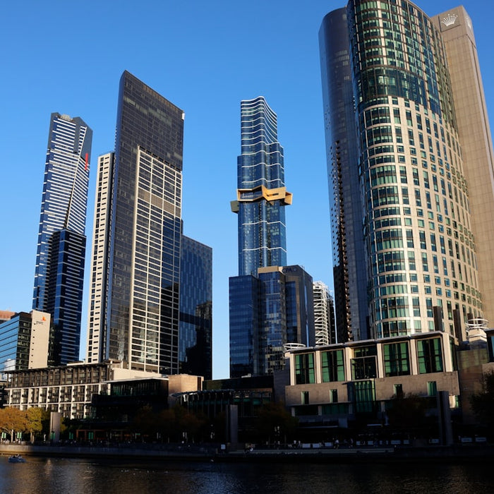 Modern skyscrapers rise against a clear blue sky.