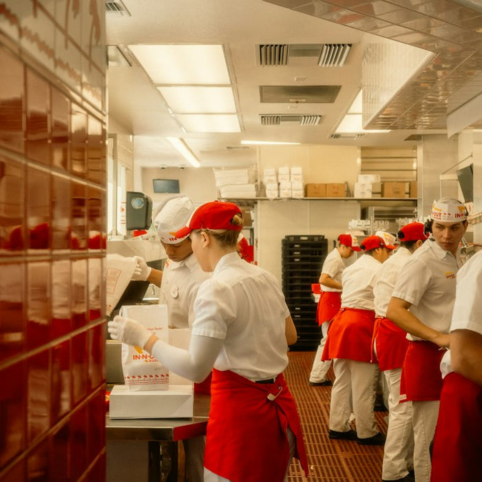 Restaurant staff in red aprons working in a kitchen