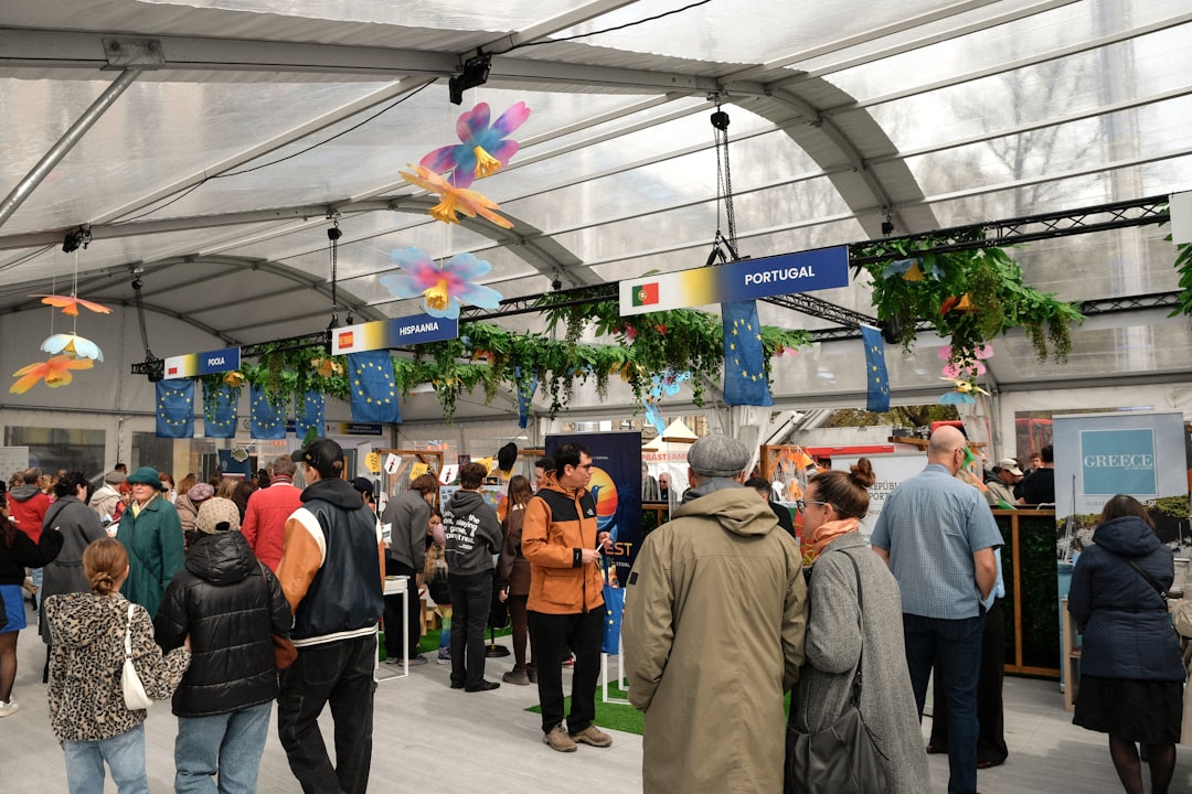 Crowd gathered inside a large tent with decorated stalls.