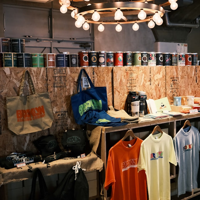 Shop interior featuring apparel, accessories, and cans on wooden displays.