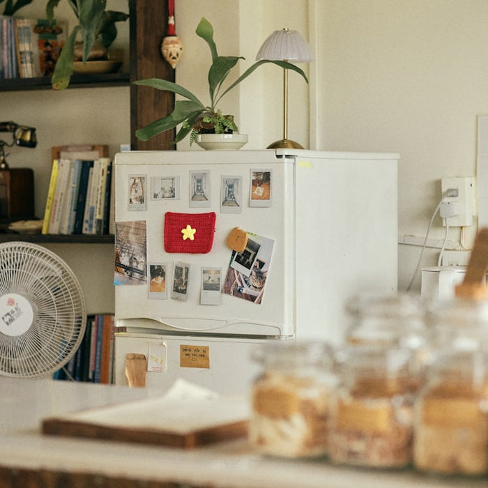 Refrigerator with flag magnet, fan, and jars on a counter