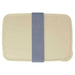 Seasons Dovi 800 ml Lunch Box - A cream-coloured lunch box with a denim-style elastic band. The design features a simple, rectangular shape and a logo.