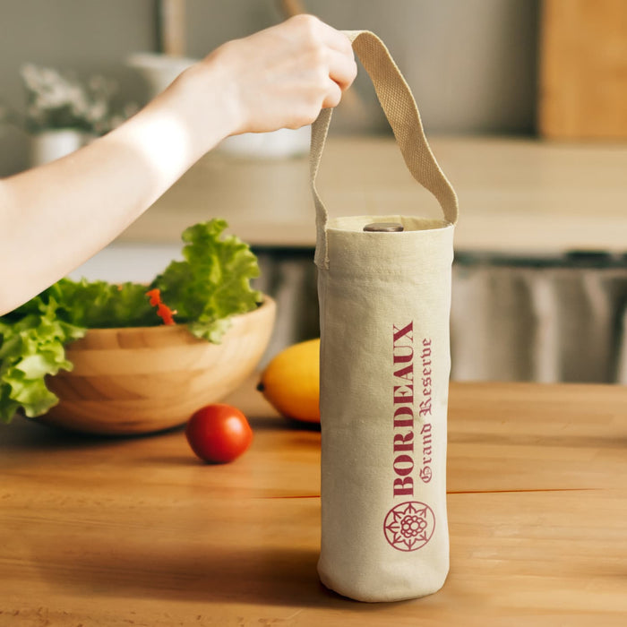 Cotton Wine Tote Bag - A cotton wine tote bag in natural colour with a logo, held by a hand. There are vegetables and fruits in the background.