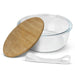 NATURA Iris Glass Food Container - A glass food container with a wooden lid and a white elastic band. The container is clear and round.