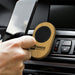 Bamboo Car Phone Holder - A bamboo car phone holder with a black circular grip, placed in a car dashboard vent, holding a smartphone.