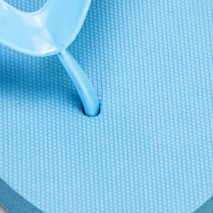 Tidal Flip Flops - A close-up of a light blue Tidal Flip Flop with a thong strap and textured footbed. Features a logo.