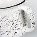 Bendigo Ceramic Mug - A ceramic mug with a speckled white design and a black rim, featuring a sturdy handle.