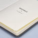 Pierre Cardin Nouvelle Notebook Gift Set - Special - A black notebook with a yellow page marker, featuring a logo. Opened to show the title page inside.