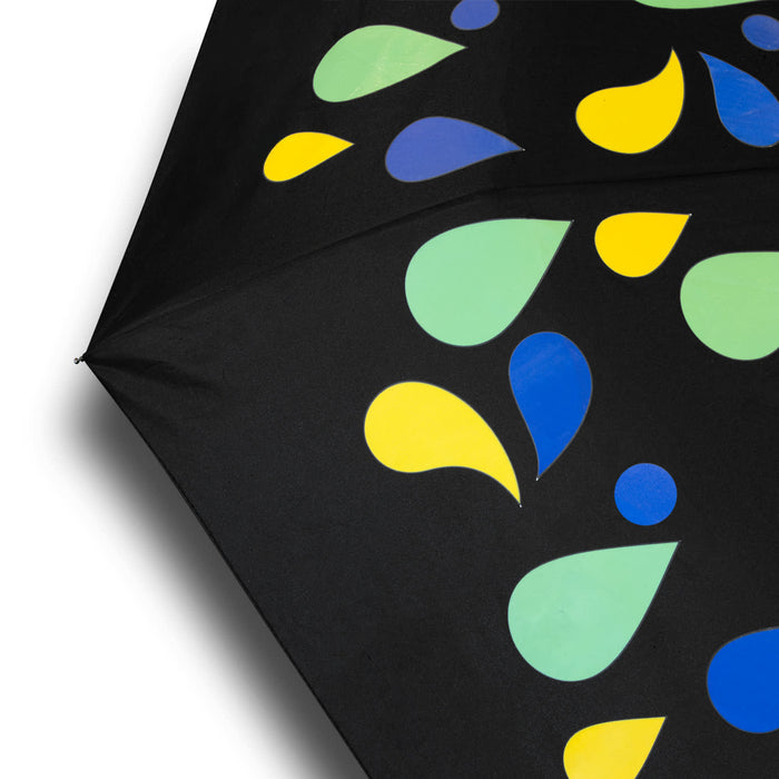 Colour Changing Compact Umbrella - A compact umbrella featuring a black canopy adorned with colourful droplets in green, yellow, and blue. It has a branding logo.