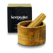 Keepsake Mortar & Pestle - A wooden mortar and pestle set in a round bowl, displayed with a black box featuring a logo.