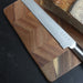 Keepsake Chopping Board - A wooden chopping board with a patterned design, featuring a stainless steel knife and a loaf of bread.