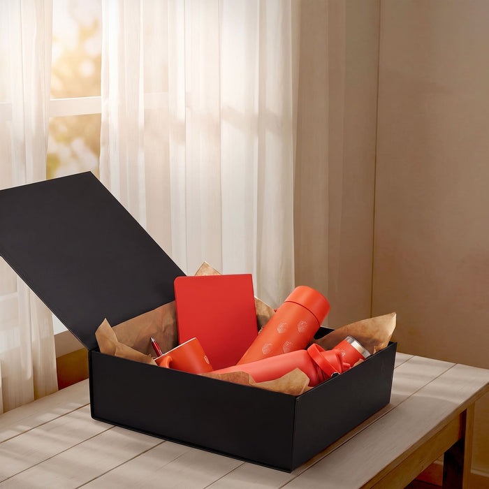 Magnetic Lid Gift Box - Large - A large black gift box filled with various orange items, including drink bottles and a notebook, resting on a wooden table.