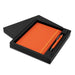 Omega Notebook and Pen Gift Set - An orange notebook and pen set in a black box with a logo.