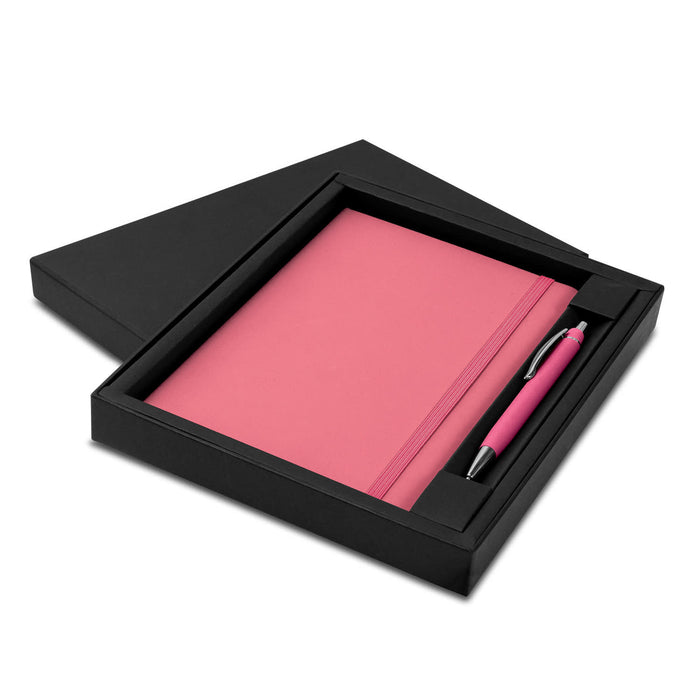 Omega Notebook and Pen Gift Set - A pink notebook and matching pen presented in a black gift box. It features a sleek design with a logo.