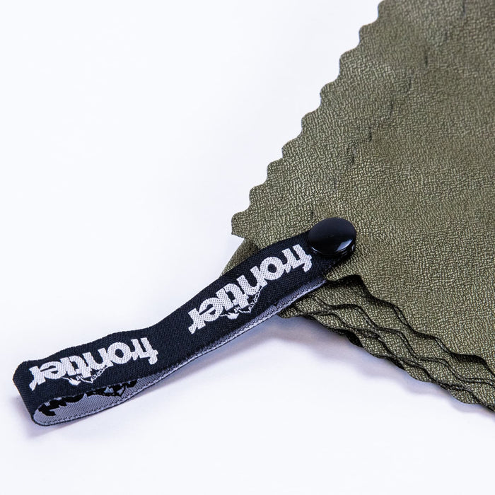 Frontier Rapid Dry Towel - A green cooling towel with a black strap featuring a logo. The towel has a textured surface and is neatly folded.
