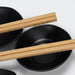 Keepsake Sushi Set - A set of black bowls accompanied by wooden chopsticks, featuring a simple and elegant design.