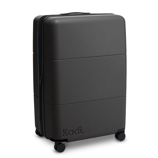 Kadi Check-In Suitcase - Large - A large black suitcase with a smooth exterior and wheels, featuring a brand logo on the side.