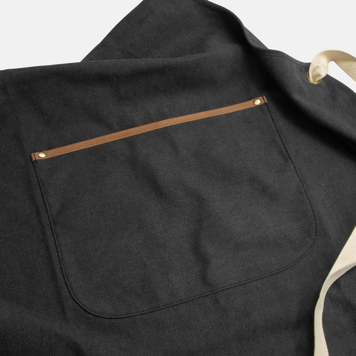 Keepsake Canvas Apron & Oven Mit Set - A dark grey canvas apron with a brown pocket and cream-coloured straps.