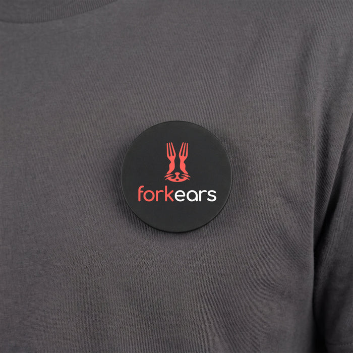 Multi-Functional Magnetic Badge - A round black magnetic badge featuring a logo and placed on a grey shirt.