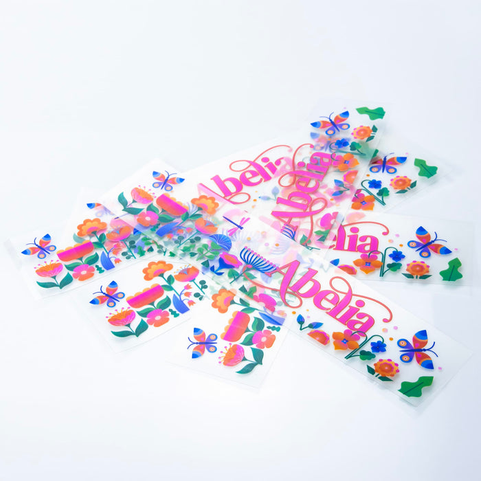 Prism Print - 250 x 50mm Sticker - A collection of colourful stickers featuring floral and butterfly designs, displayed against a white background.