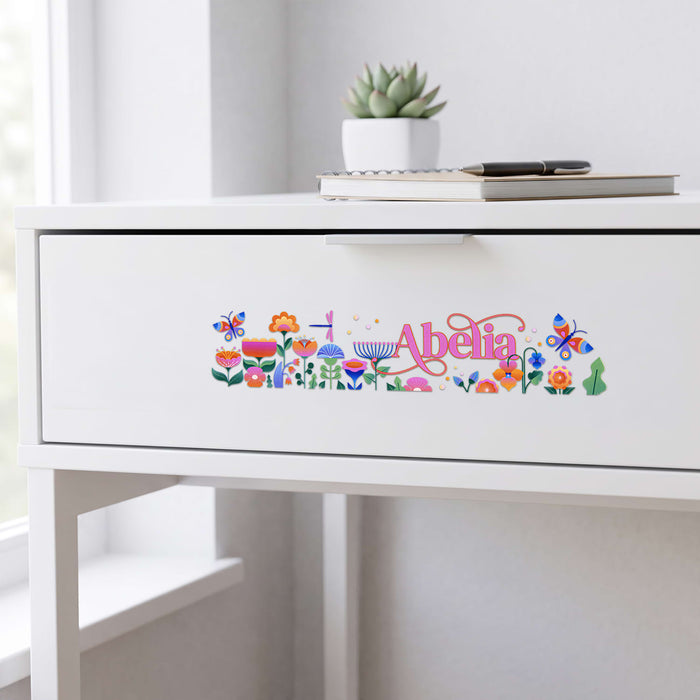 Prism Print - 250 x 50mm Sticker - A drawer with a white finish featuring a colourful floral sticker with butterflies and the name "Abelia".