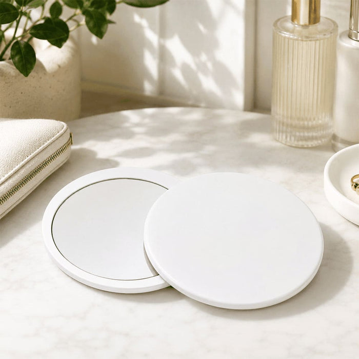 Glider slider makeup mirror - A round, white Glider slider makeup mirror with a sleek design, displayed on a marble surface with accessories.