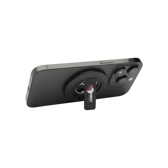 Ain Recycled Plastic Magnetic Phone Stand with Bottle Opener - A magnetic phone stand in black, featuring a bottle opener and a logo, mounted on the back of a smartphone.