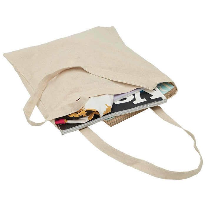 Hemp Tote - A natural-coloured hemp tote bag filled with magazines. The bag has two handles and a simple design.