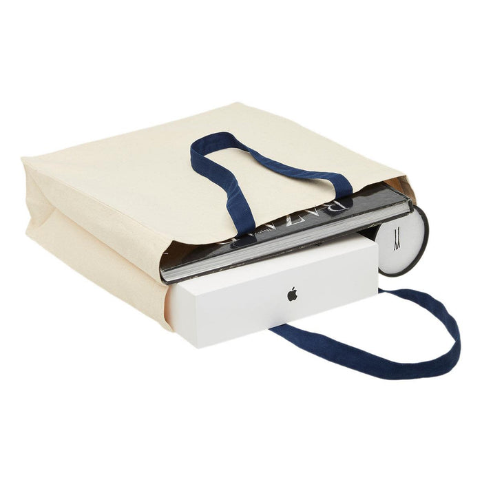 Heavy Duty Canvas Tote with Gusset - A cream heavy-duty canvas tote with navy handles, filled with various items including books and a box.