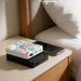 5000mah Square Power Bank - A square power bank in white with a floral design sits atop a black power bank on a bedside table next to a smartphone.