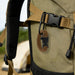Paracord Bracelet With Whistle - A brown paracord bracelet with a whistle attached to a tactical backpack strap in an outdoor setting.